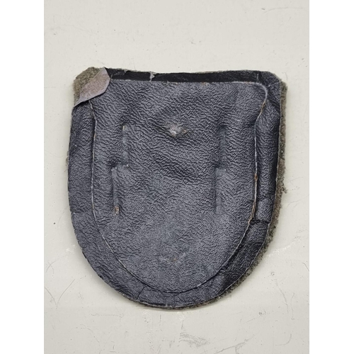 1495 - A German Third Reich Wehrmacht Kuban shield badge, 6cm high, on grey cloth panel.