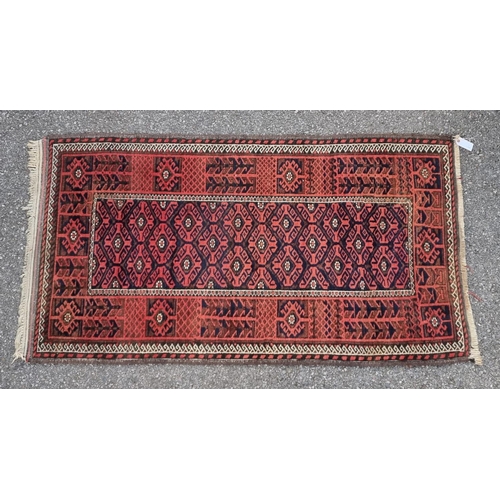 1128 - A small Turkoman rug, having geometric borders, on a red and blue ground, 162 x 88cm.... 