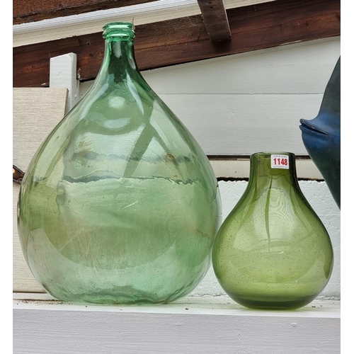 1148 - A Whitefriars style green glass baluster vase, 25.5cm high; together with another green glass carboy... 