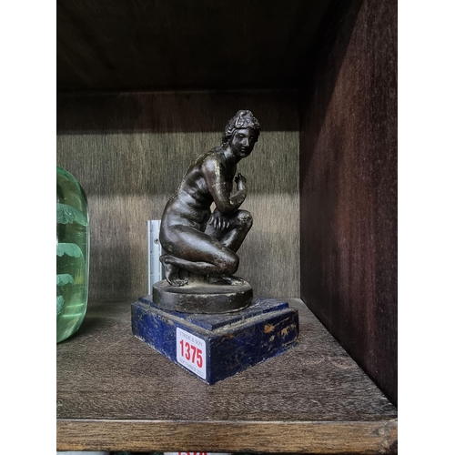 1375 - After the Antique, a bronze 'Crouching Venus', on blue marble base, 17cm high.