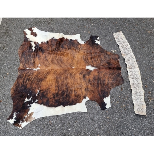 1508 - Taxidermy: a cow hide rug; together with a snake skin panel, 190cm long.