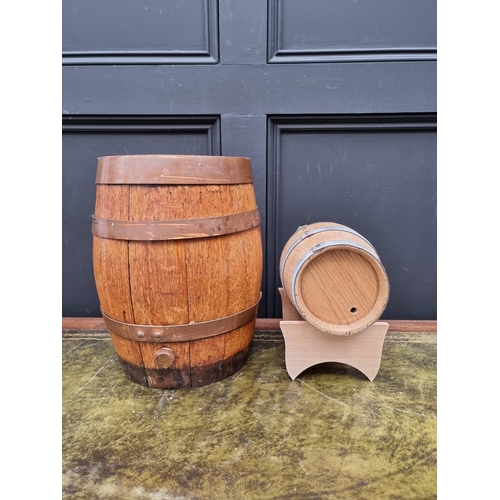 1553 - A small oak and copper coopered barrel, 34cm wide; together with a smaller coopered barrel on stand.... 