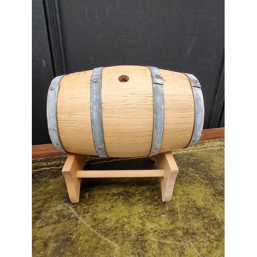 1553 - A small oak and copper coopered barrel, 34cm wide; together with a smaller coopered barrel on stand.... 