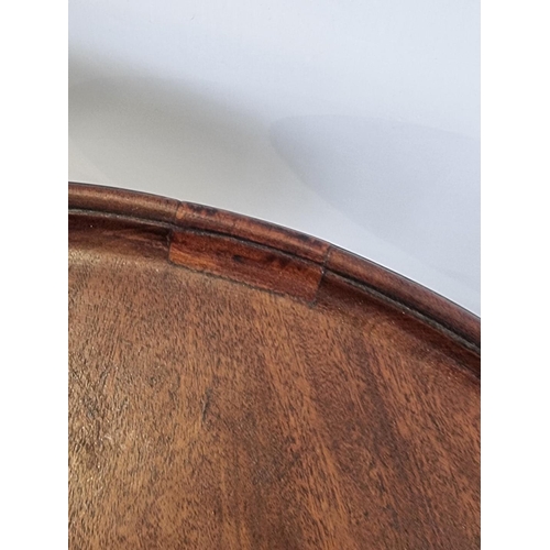 1100A - A George III mahogany circular tripod table, with fixed dished top, 46.5cm diameter.... 