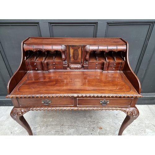 1057 - Au unusual reproduction carved mahogany desk, 103.5cm wide. 