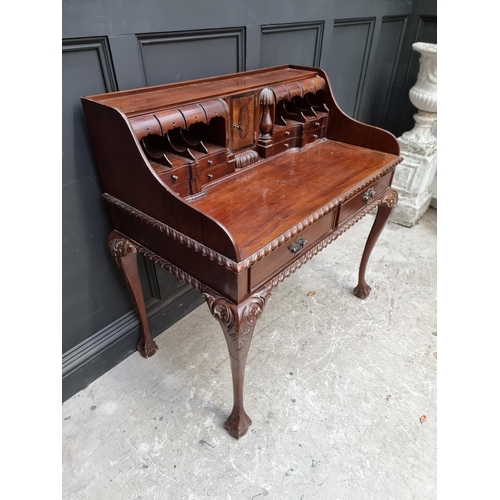 1057 - Au unusual reproduction carved mahogany desk, 103.5cm wide. 