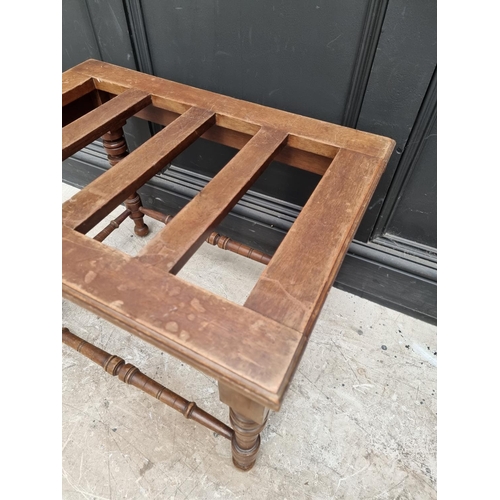 1070 - An Edwardian walnut luggage stand, 65.5cm wide.