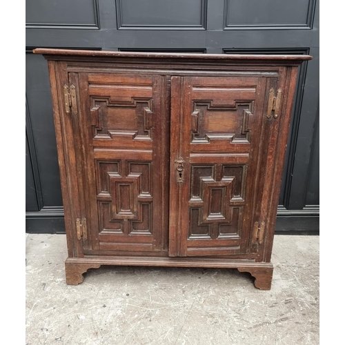 1073 - An unusual 17th century and later oak panelled cabinet, enclosing an arrangement of nine drawers, 11... 