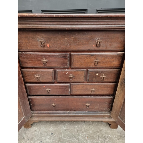 1073 - An unusual 17th century and later oak panelled cabinet, enclosing an arrangement of nine drawers, 11... 