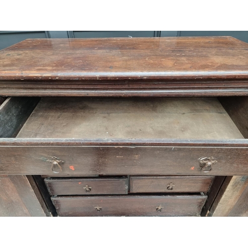 1073 - An unusual 17th century and later oak panelled cabinet, enclosing an arrangement of nine drawers, 11... 