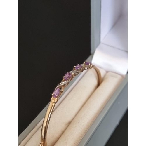 461 - An amethyst and diamond hinged bangle, stamped '9k'.