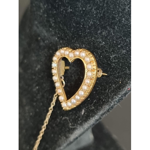 486 - An Edwardian yellow metal pearl set open heart shaped brooch, 2.5cm high.