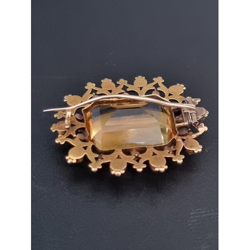 503 - A Victorian yellow metal oval brooch, set rectangular facetted citrine surrounded by ten rubies and ... 