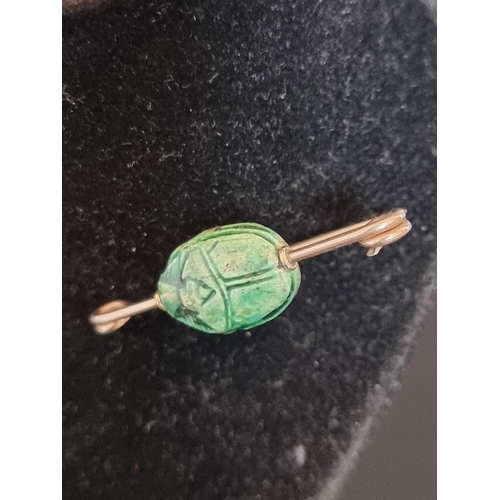 513 - An early 20th century yellow metal bar brooch, set central revolving green ceramic scarab beetle, 4c... 