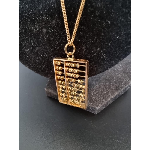 516 - A yellow metal abacus pendant, stamped '14k', 32mm, on a gold plated chain.