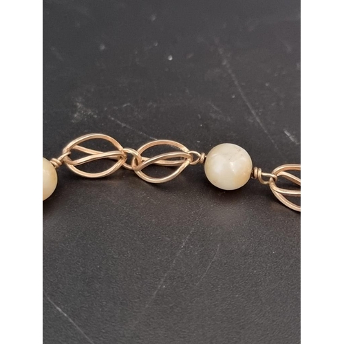 542 - A vintage yellow metal fancy link bracelet, having five interspersed pearls, 20cm.