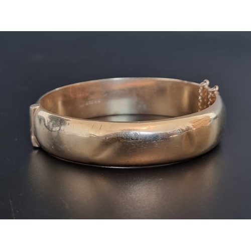 545 - A 9ct gold hinged bangle, 62mm maximum internal size, 21g.