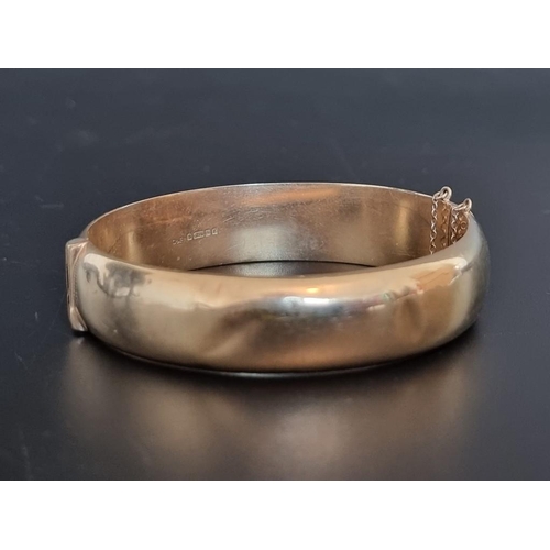 545 - A 9ct gold hinged bangle, 62mm maximum internal size, 21g.