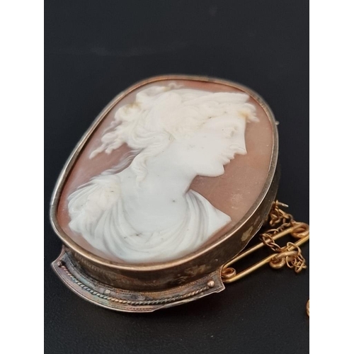 557 - A yellow metal carved shell cameo, in a yellow metal mount, 46mm high; together with another similar... 