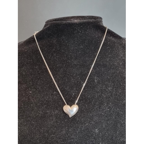 572 - A silver heart pendant, on a white metal necklace chain stamped '935'.