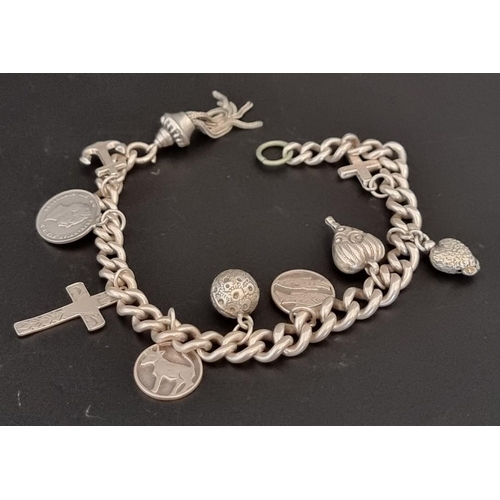 575 - A white metal curb link charm bracelet, with nine charms.