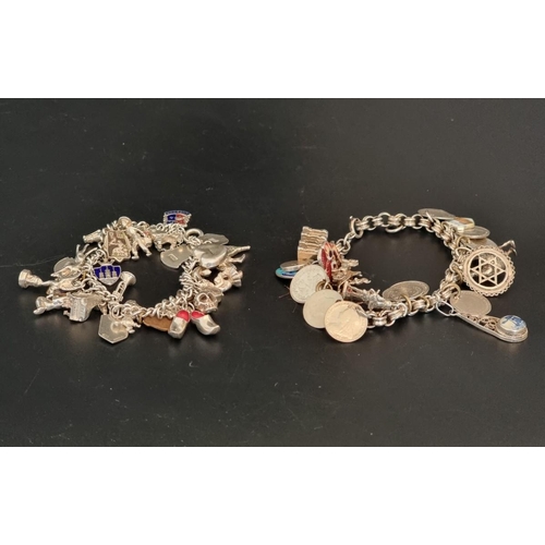 582 - Two white metal charm bracelets, with multiple attached .800, sterling and other charms. (2)... 