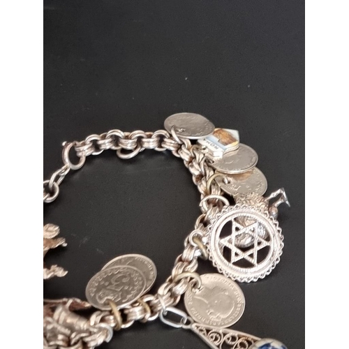 582 - Two white metal charm bracelets, with multiple attached .800, sterling and other charms. (2)... 