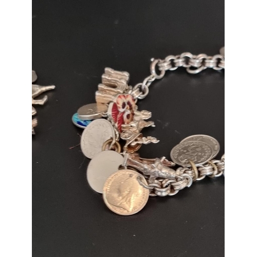 582 - Two white metal charm bracelets, with multiple attached .800, sterling and other charms. (2)... 