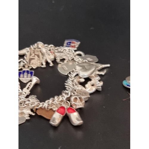 582 - Two white metal charm bracelets, with multiple attached .800, sterling and other charms. (2)... 