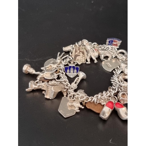 582 - Two white metal charm bracelets, with multiple attached .800, sterling and other charms. (2)... 