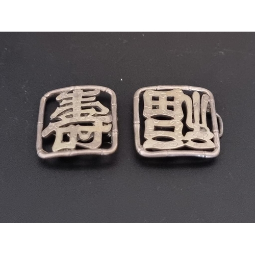 600 - A pair of Chinese metal buckles, decorated characters within a stylised bamboo frame, 4.5cm.... 