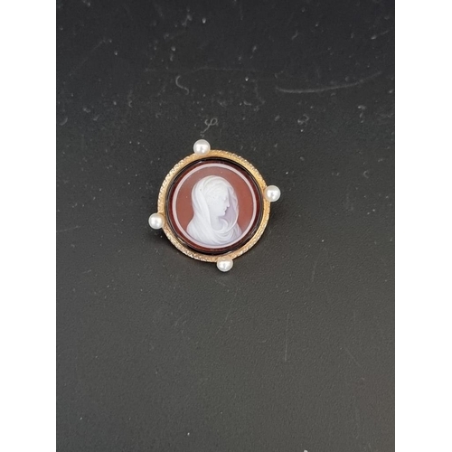 485 - A Victorian carved hardstone cameo brooch, set four pearls to the yellow metal frame, 23mm diameter.... 