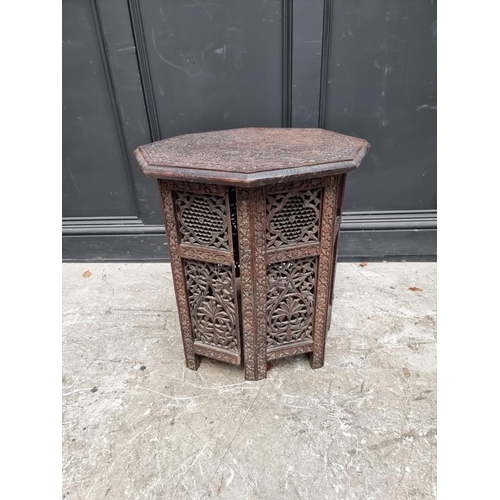 1072 - An Eastern carved hardwood octagonal folding table, 53cm diameter.