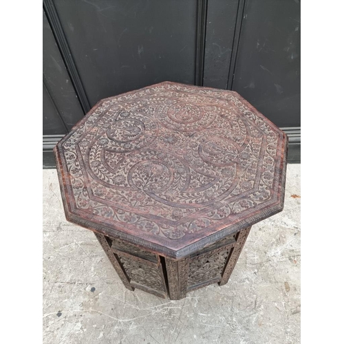 1072 - An Eastern carved hardwood octagonal folding table, 53cm diameter.