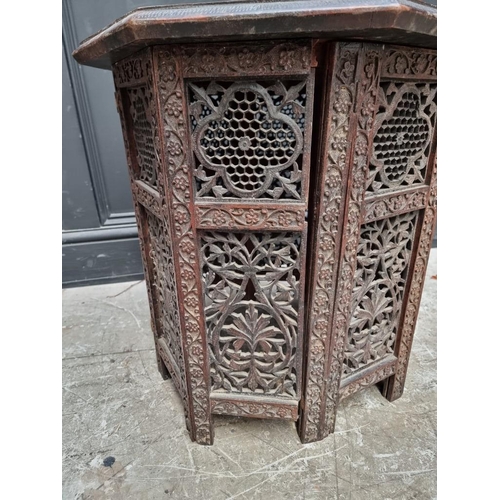 1072 - An Eastern carved hardwood octagonal folding table, 53cm diameter.