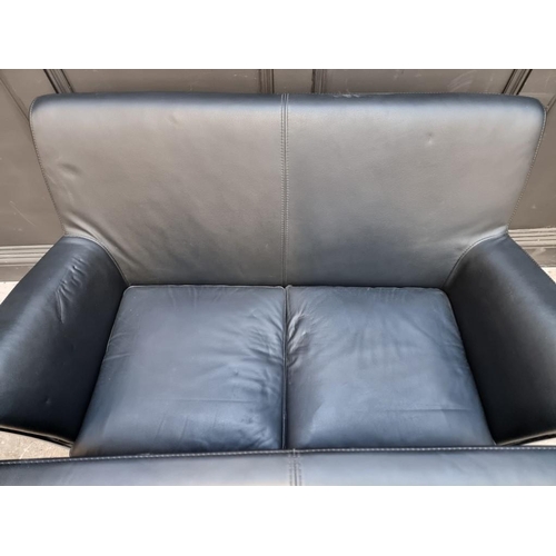 1073 - A pair of contemporary black leather and chrome sofas, by Giulio Marelli, each 123cm wide. ... 