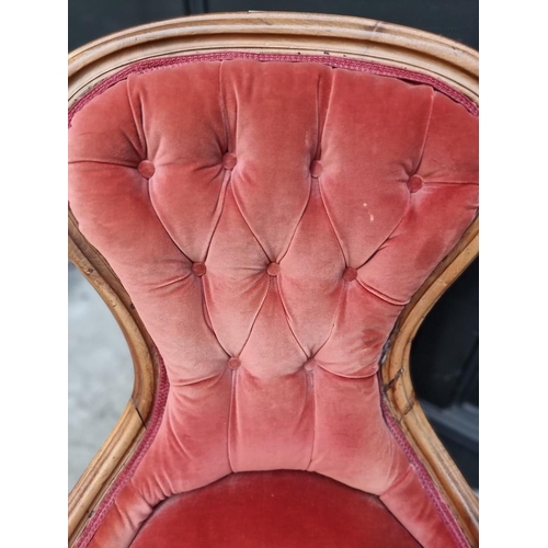 1090 - A Victorian walnut and button upholstered nursing chair. 