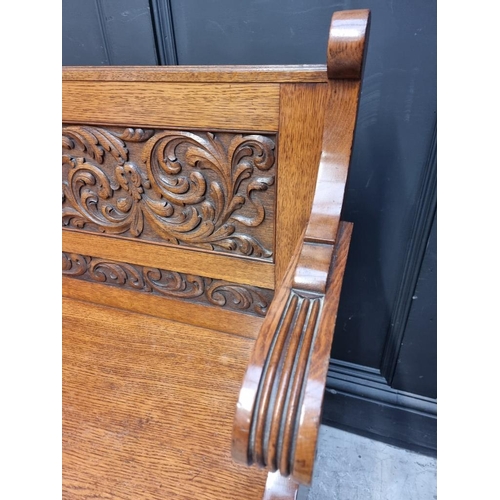 1101 - An early 20th century carved oak settle, 125cm wide.