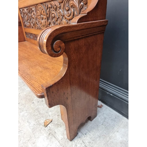 1101 - An early 20th century carved oak settle, 125cm wide.