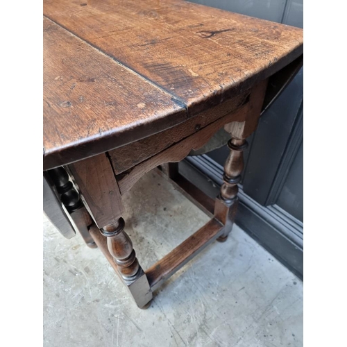 1115 - An early 18th century oak gateleg table, with two opposing frieze drawers, 145.5cm long. ... 