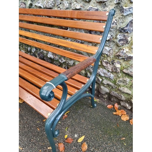 1121 - A green painted cast iron and hardwood garden bench, 126.5cm wide, (freshly restored).... 