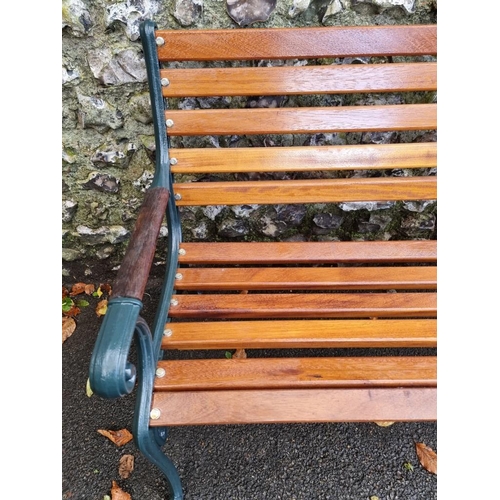 1121 - A green painted cast iron and hardwood garden bench, 126.5cm wide, (freshly restored).... 