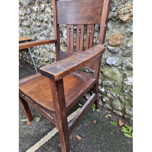 1124 - An unusual Arts & Crafts oak elbow chair, (split to seat).