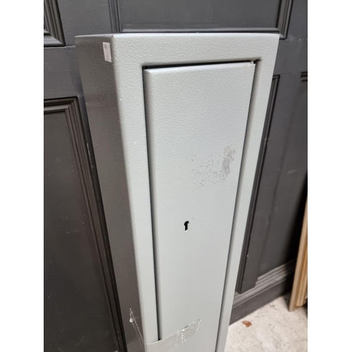 1135 - A steel gun cabinet, 131cm high x 21.5cm wide, with two pairs of keys.  ... 