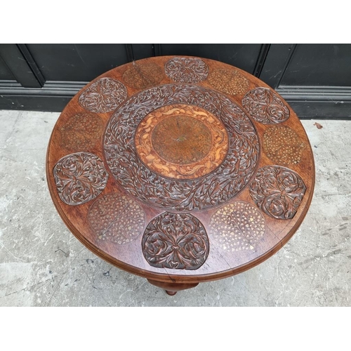 1109 - A Indian carved hardwood, brass and inlaid circular low occasional table, 90cm diameter.... 