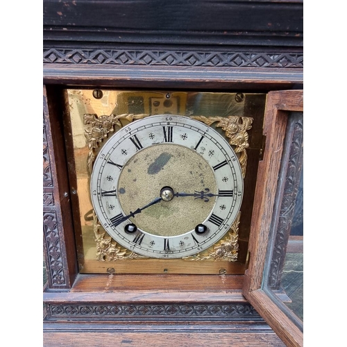 1163 - An oak mantel clock, striking on two gongs, 32.5cm high, with pendulum. 