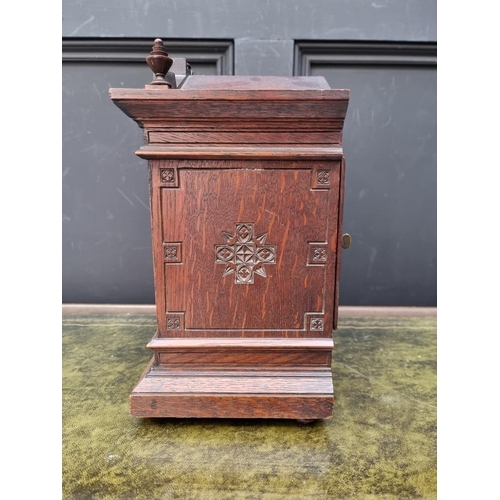 1163 - An oak mantel clock, striking on two gongs, 32.5cm high, with pendulum. 