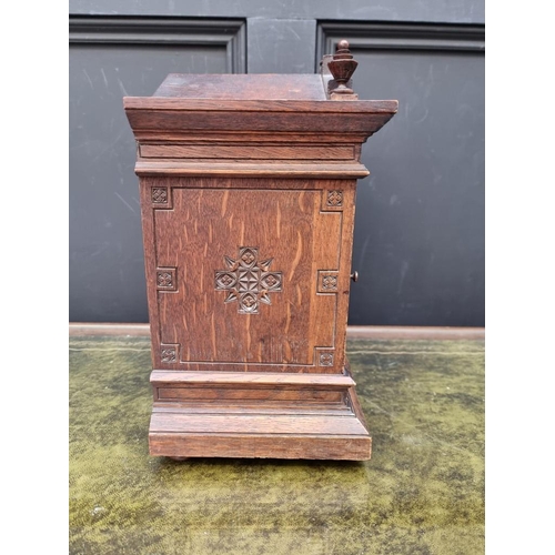 1163 - An oak mantel clock, striking on two gongs, 32.5cm high, with pendulum. 