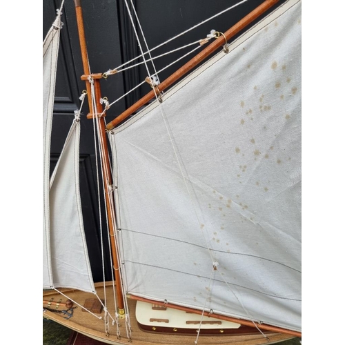 1191 - A painted wood model boat, 90.5cm long, on stand. 