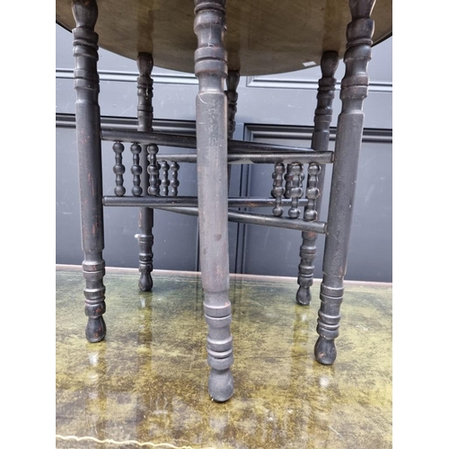 1061 - A brass circular table, on ebonized folding stand, 59cm diameter. 